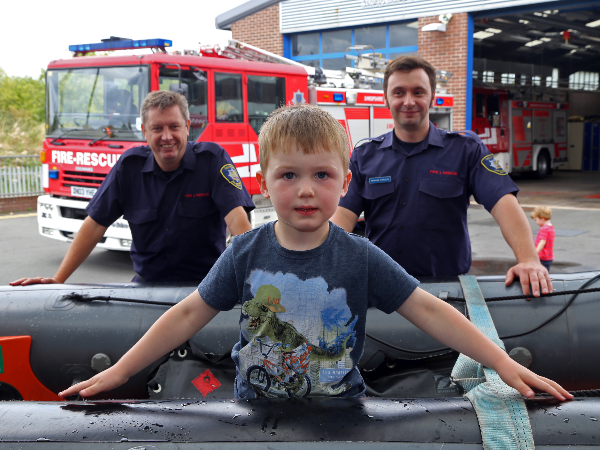 Jack Loughnane, age 3 with firefighters John Bee (left) and Graham Carless (right)