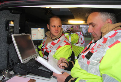 Two firefighters working at a computer inside the command vehicle