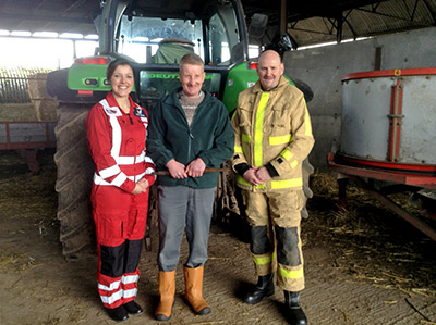 Posing to camera in front of tractor in a barn