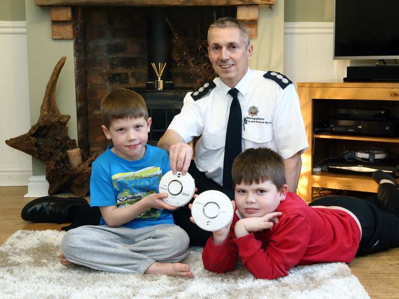 Ben (7) and Dillon (9), pictured with their own smoke alarms, get a visit from Guy Williams of Shropshire Fire and Rescue Service.